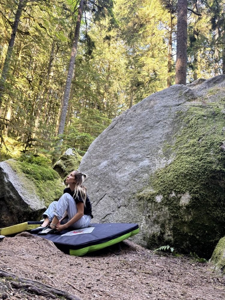 Jenni by a mossy boulder in the forest
