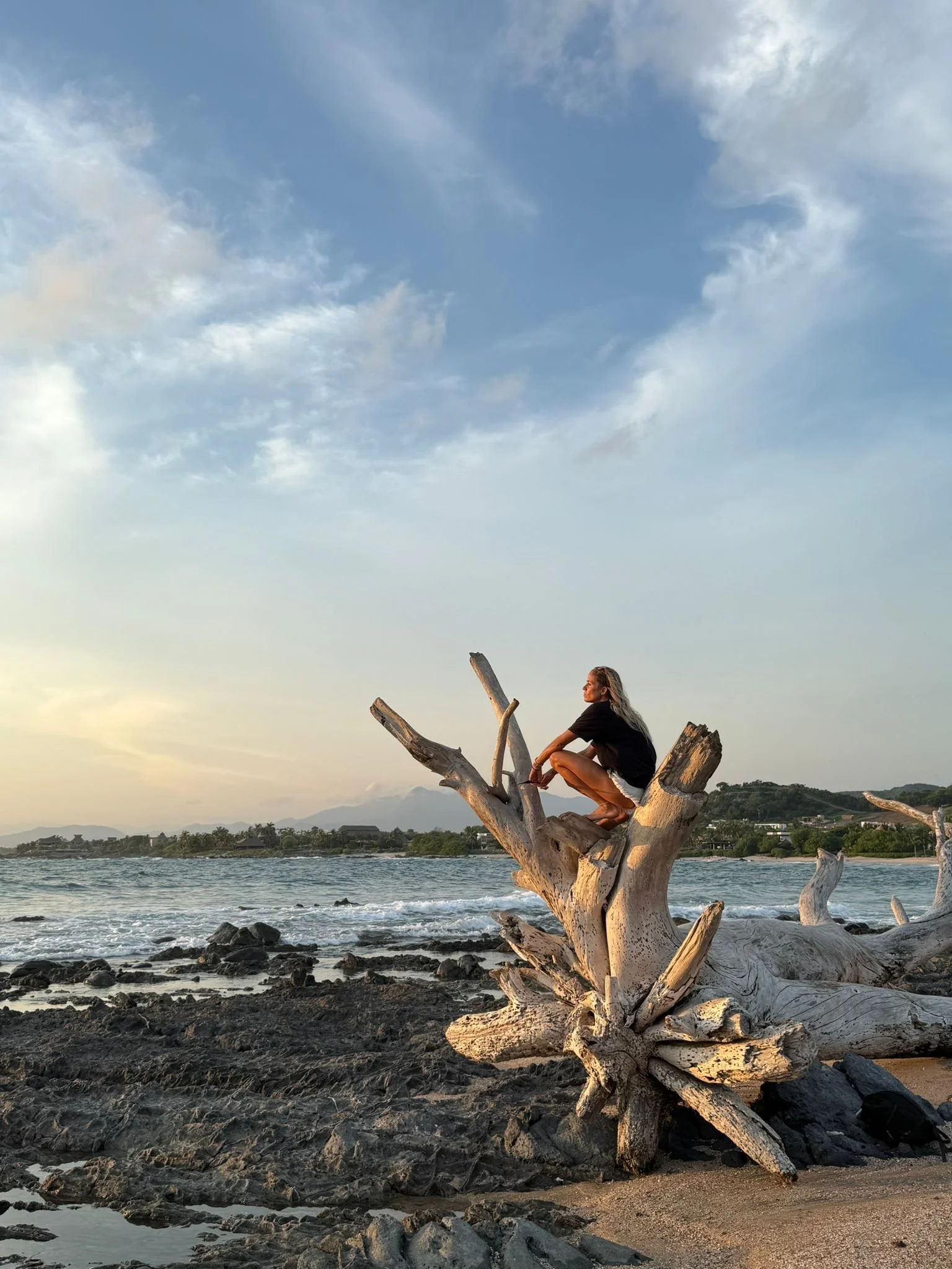 Jenni perched on driftwood at sunset
