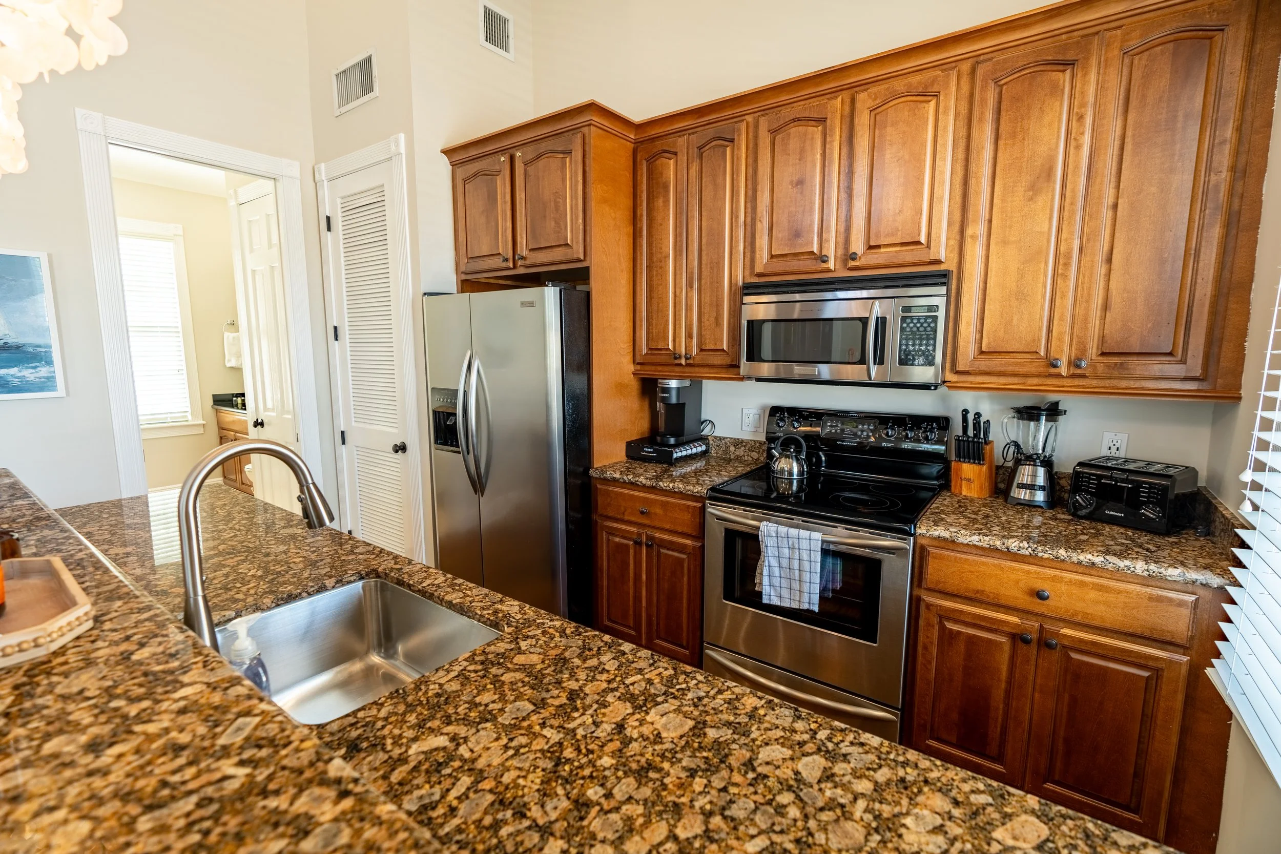 A kitchen with granite countertops, stainless steel appliances, and wooden cabinets.