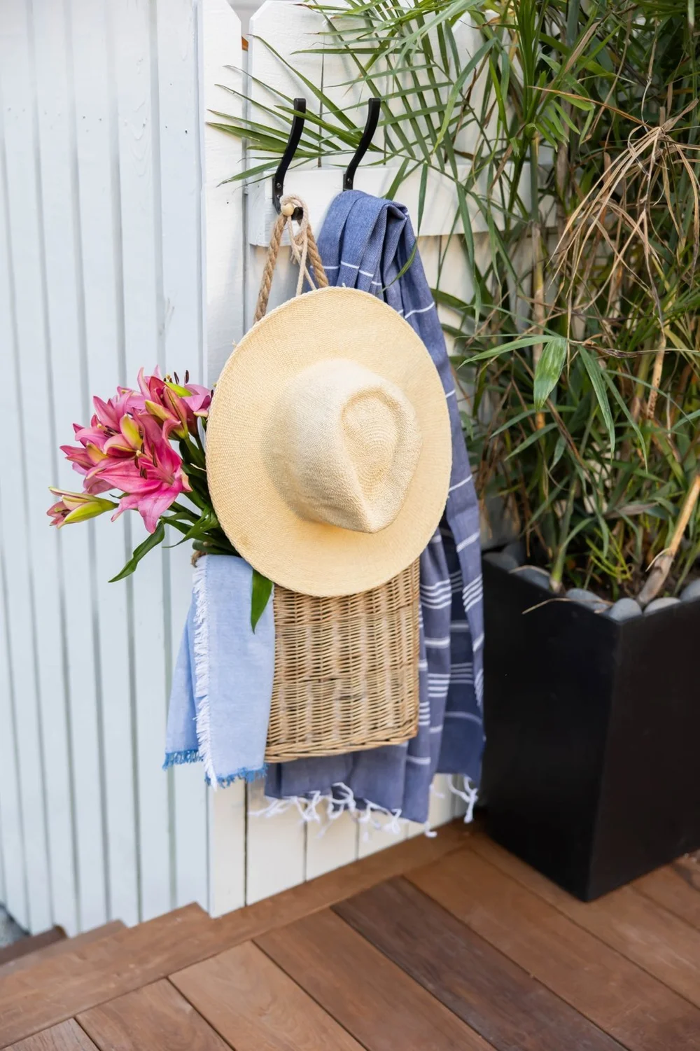 Pool towel and sun hat hanging beside a tropical garden