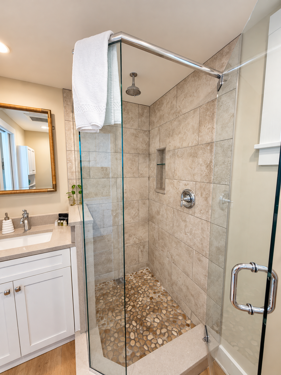 Glass walk-in shower with pebble floor and vanity at Key West Lighthouse Suite