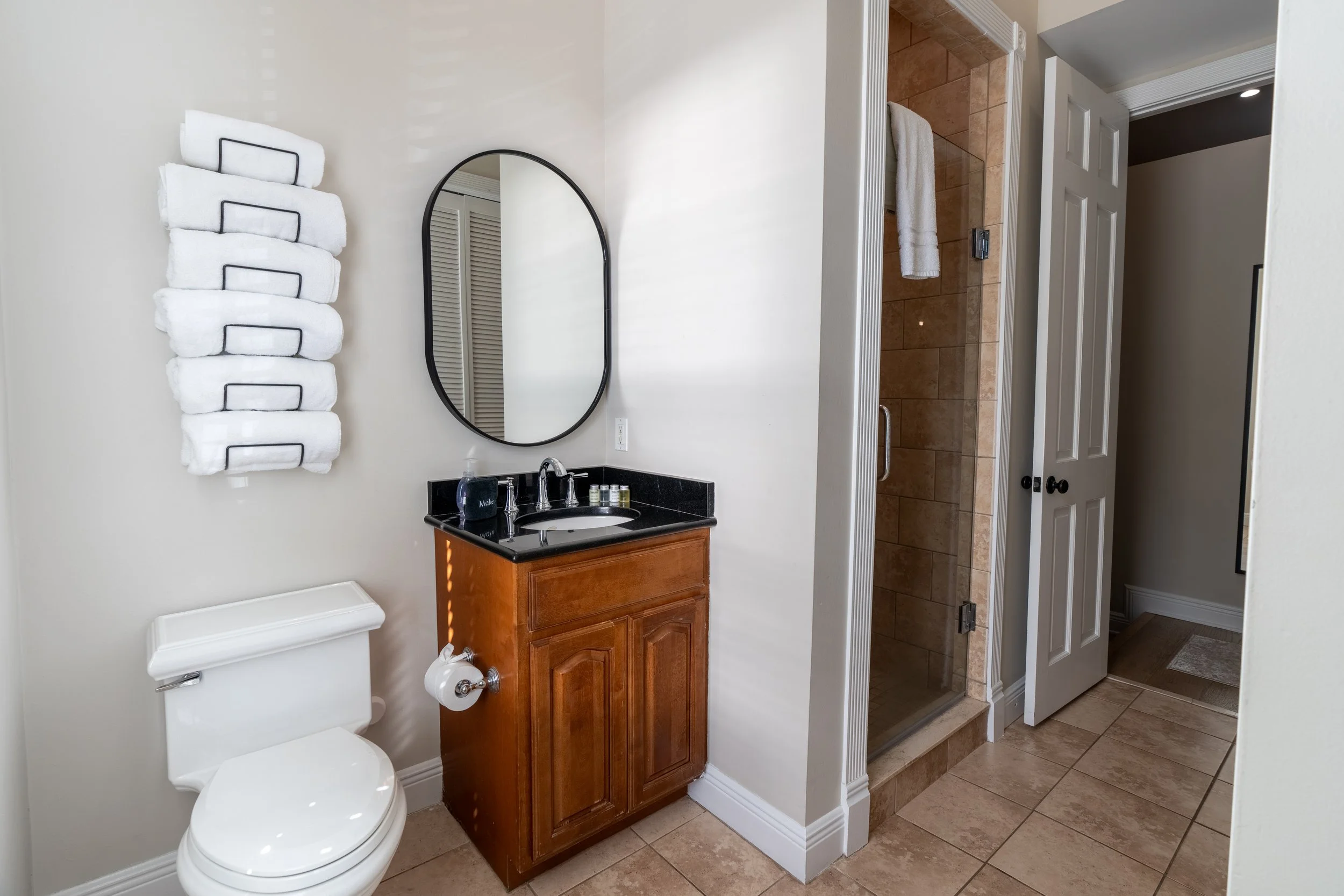 A standard bathroom with a toilet, sink, and tiled shower