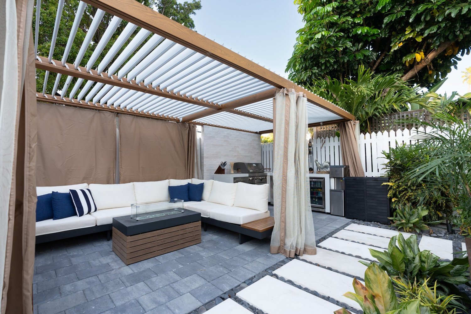 Shaded pergola with cream outdoor sofa and navy pillows