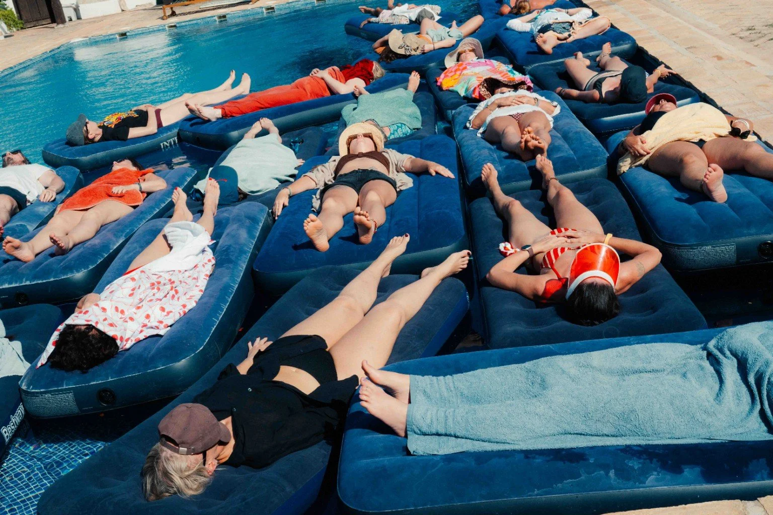 Participants resting on floating mats in the pool