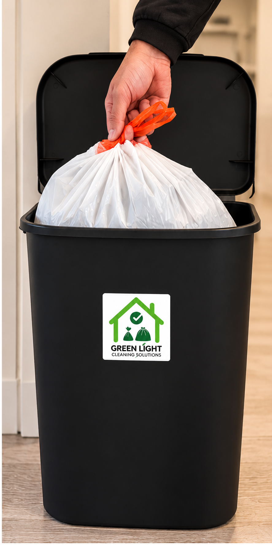 Resident placing a tied trash bag into a Green Light branded bin
