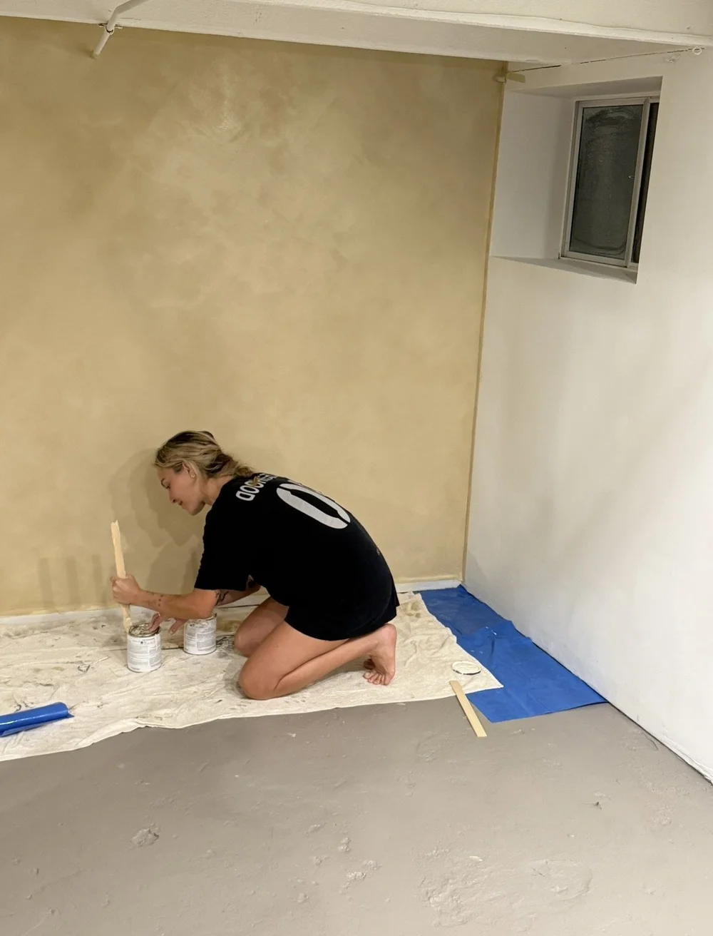 Me, mixing limewash for a warm basement accent wall
