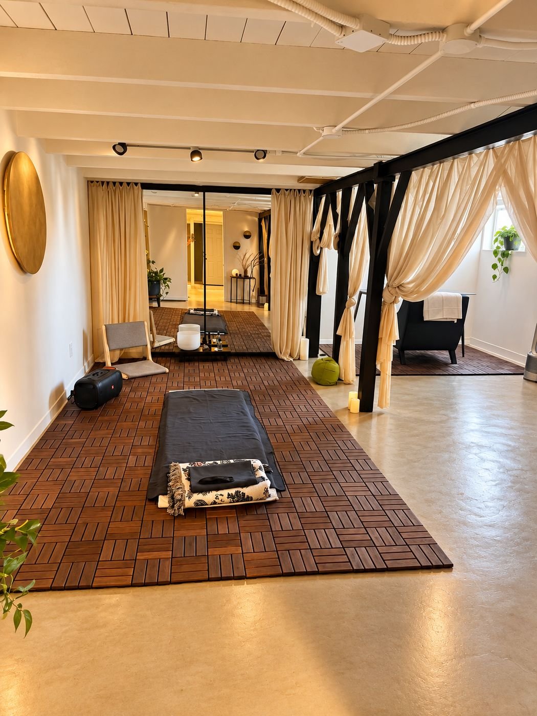 Basement after: wood deck tiles, draped curtains, track lighting and a lounge area