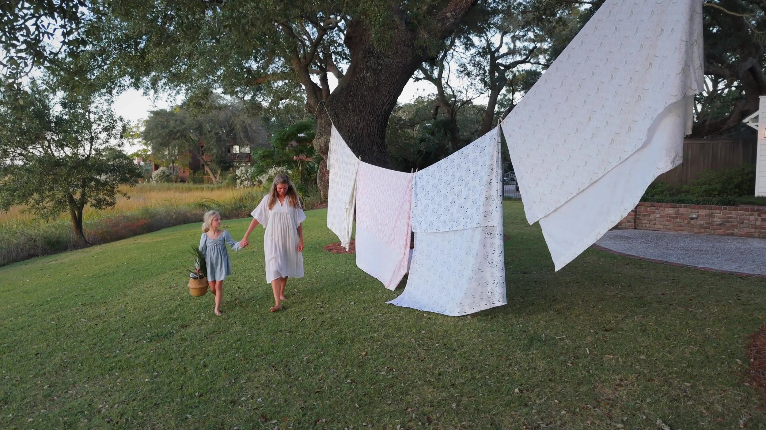 A family walking beside the textiles hanging outdoors