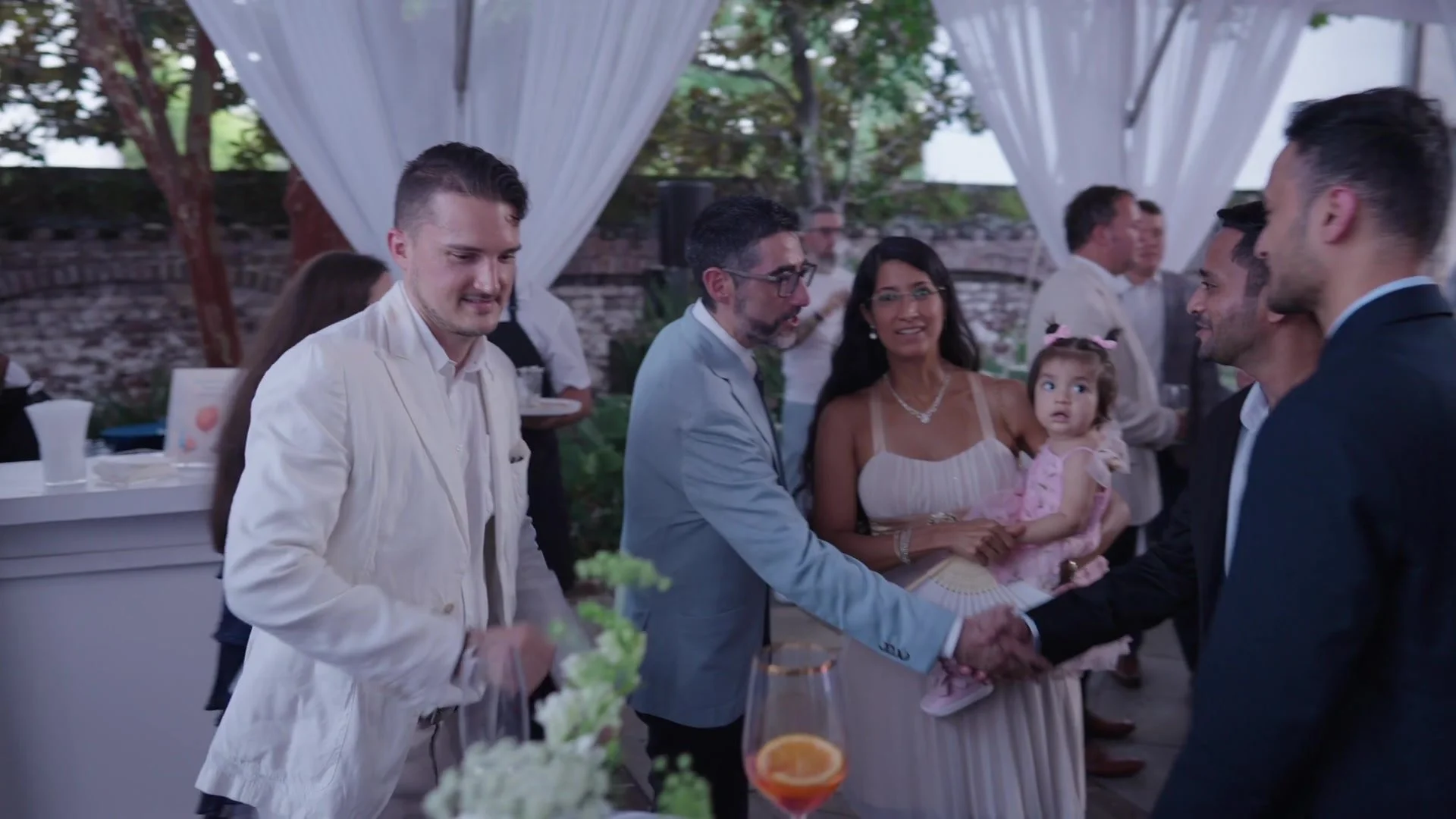 A candid greeting between guests during Night Two