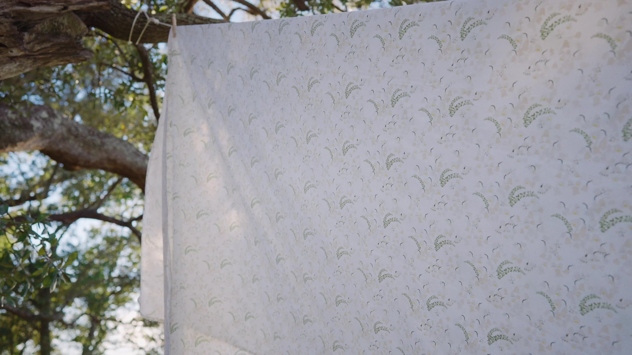 Botanical fabric hanging beneath the trees