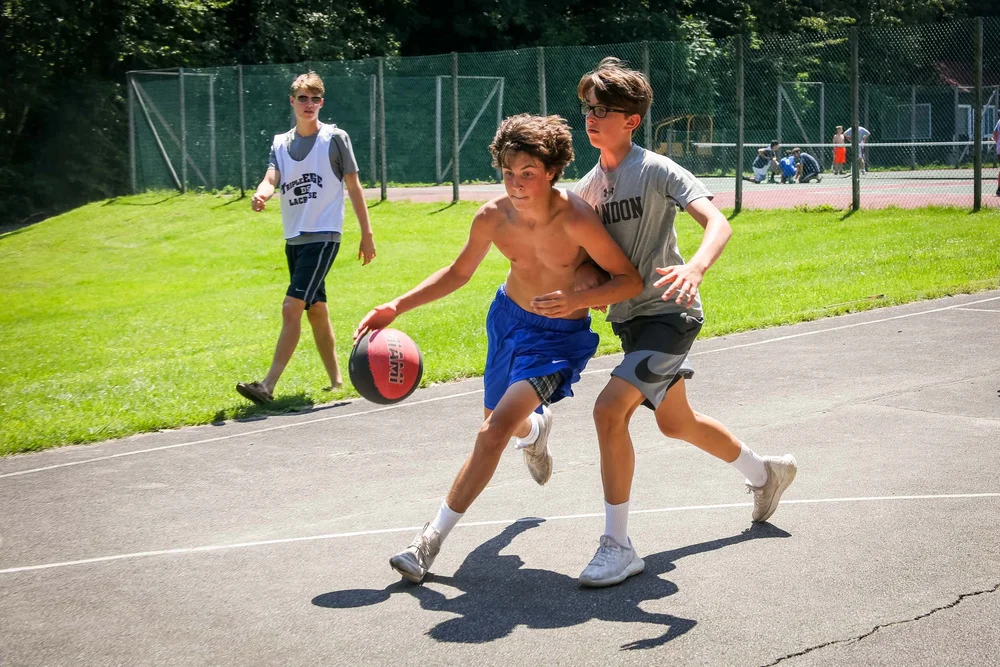 Boys competing in outdoor basketball game