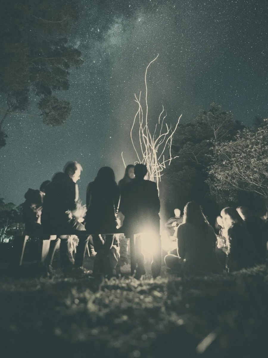 People gathered around a fire under a starry sky