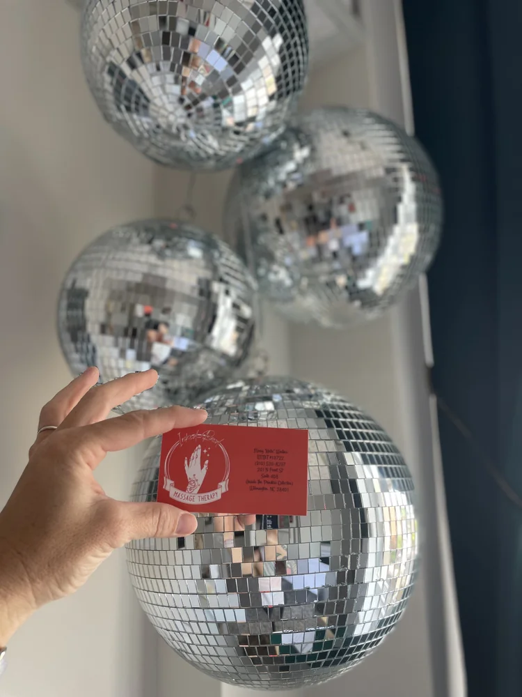 Business card held against disco balls