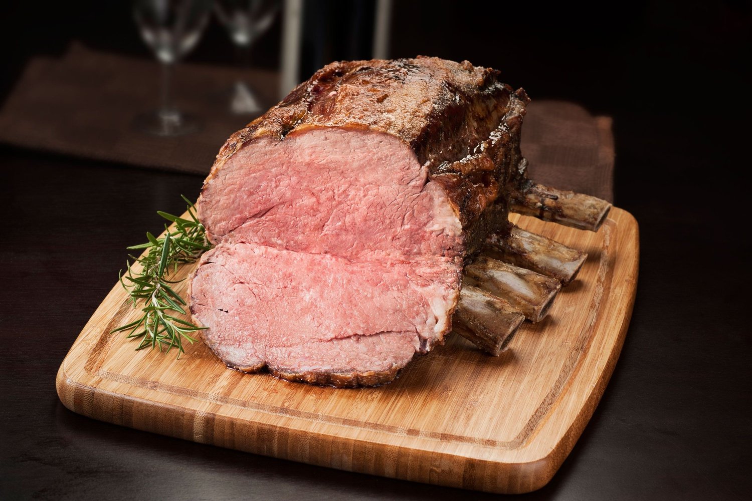 Roasted bone-in prime rib sliced on a cutting board