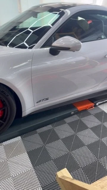 Grey Porsche 911 GTS on the lift at OCD Tinting & Wraps, Fort Walton Beach