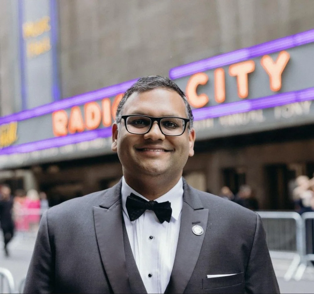 Ankit Agrawal in a tuxedo in front of the Radio City Music Hall marquee on the day of the 2025 Tony Awards