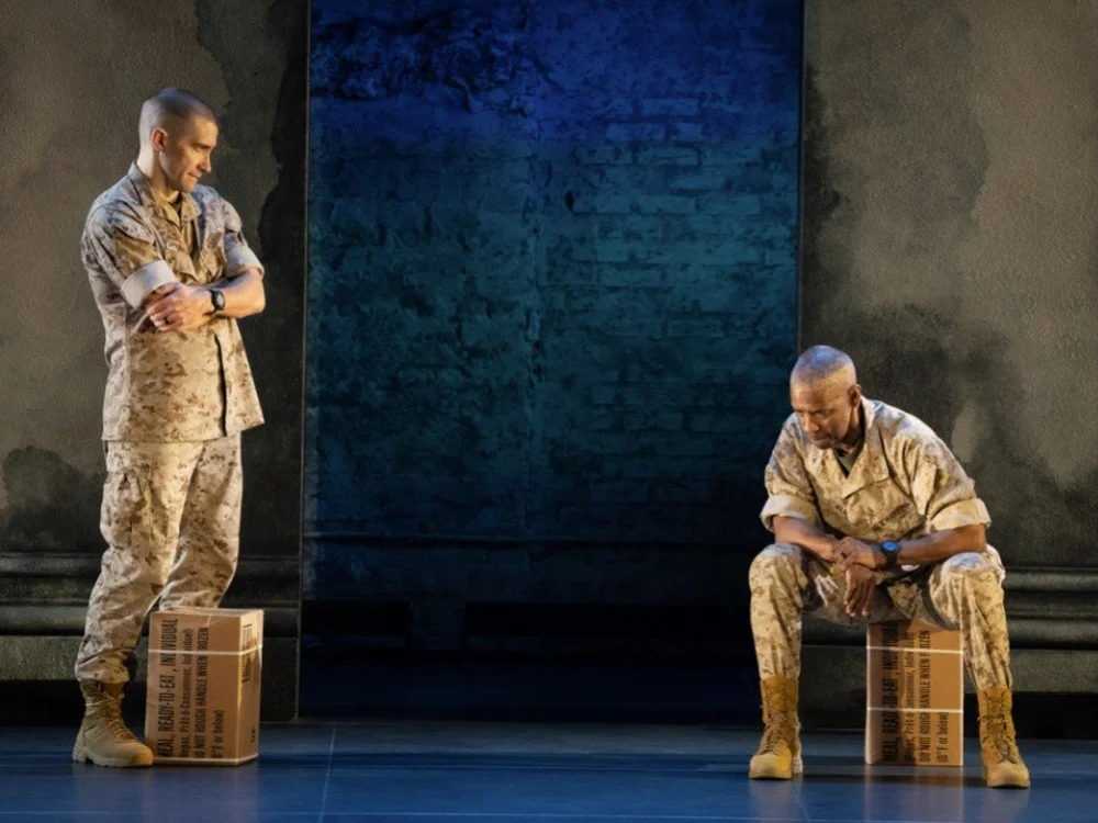 Jake Gyllenhaal as Iago and Denzel Washington as Othello in military fatigues on a bare stage