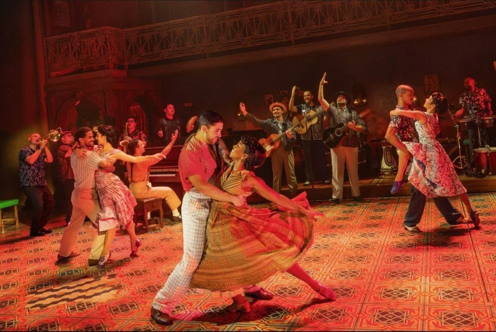 A couple dances downstage while the band plays behind them in the Buena Vista Social Club North American tour