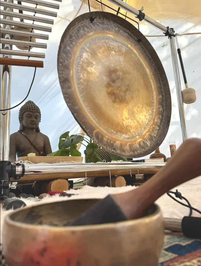 A gong and altar with a small Buddha statue