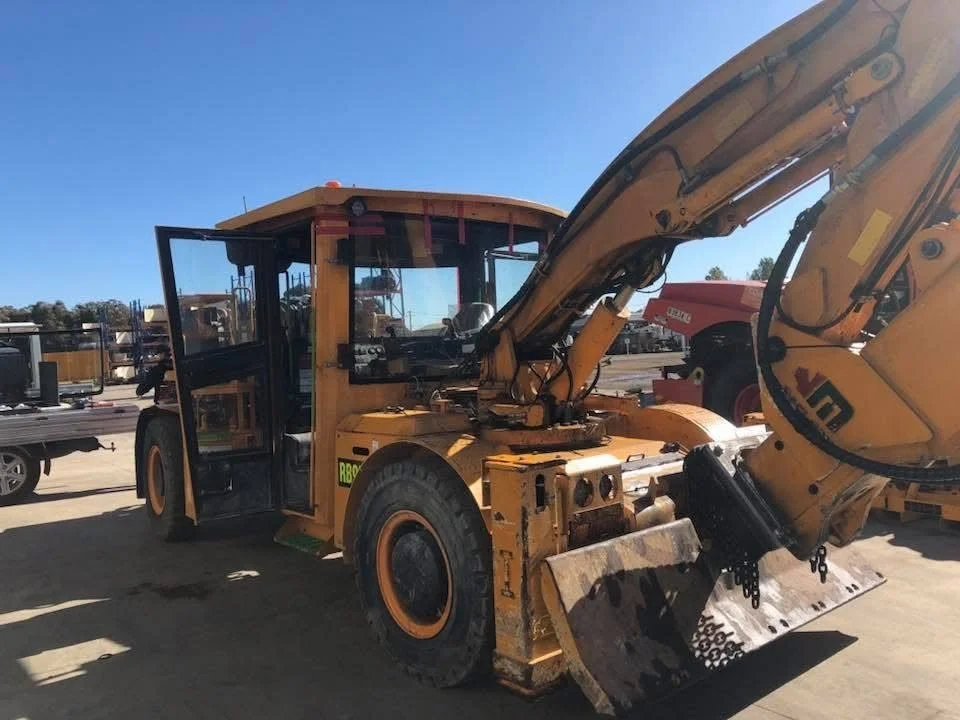 Yellow underground loader with articulated boom in the Orange Auto Glass yard for machinery glass replacement
