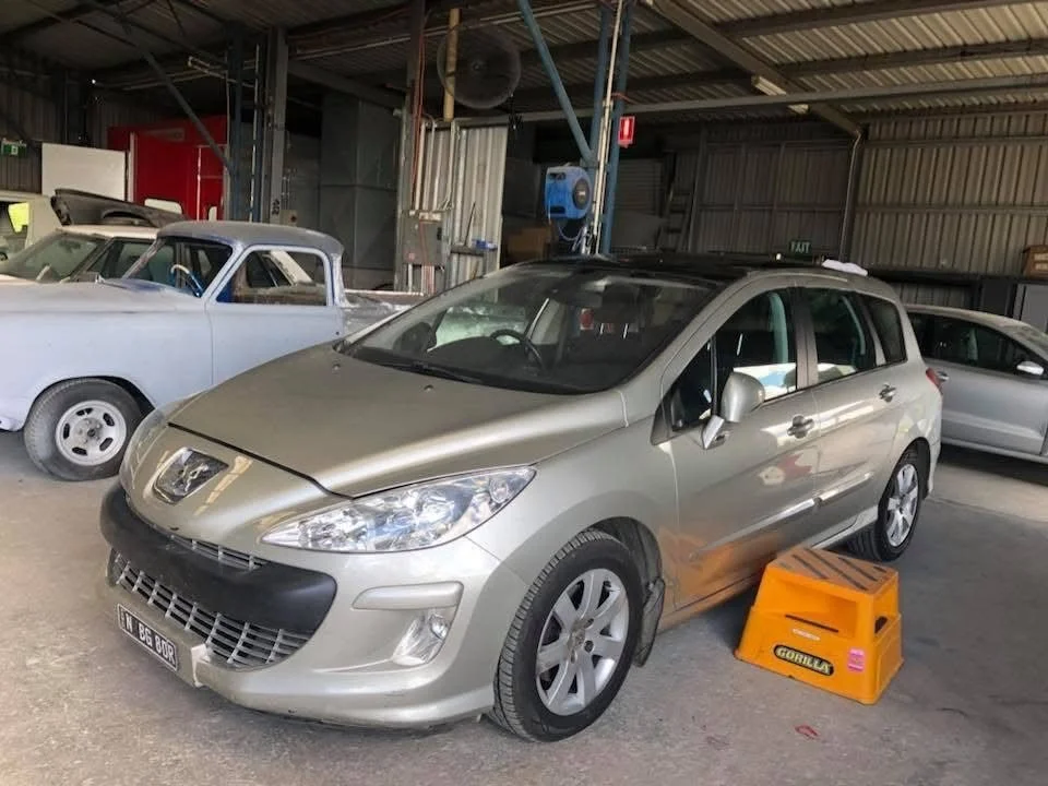 Silver Peugeot 308 wagon in the Orange Auto Glass workshop for side window and rear glass replacement