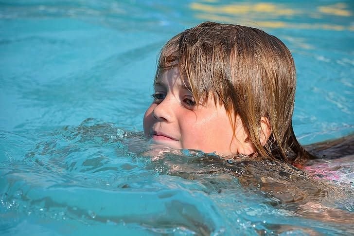 Child swimming in a clear pool