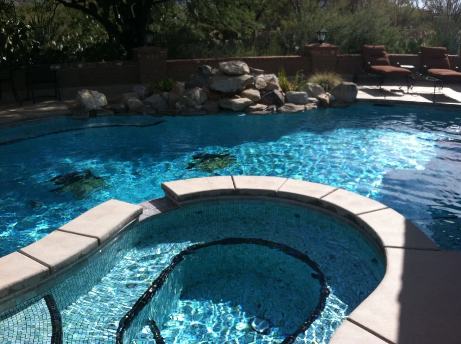 Spa set in rock beside a pool