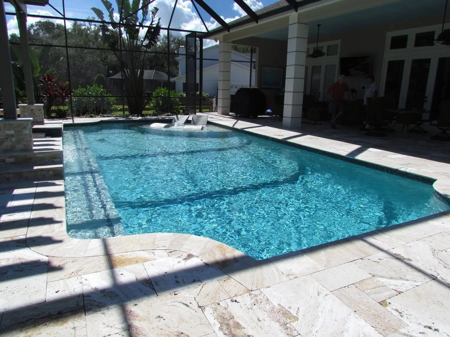 Travertine deck around a clear pool