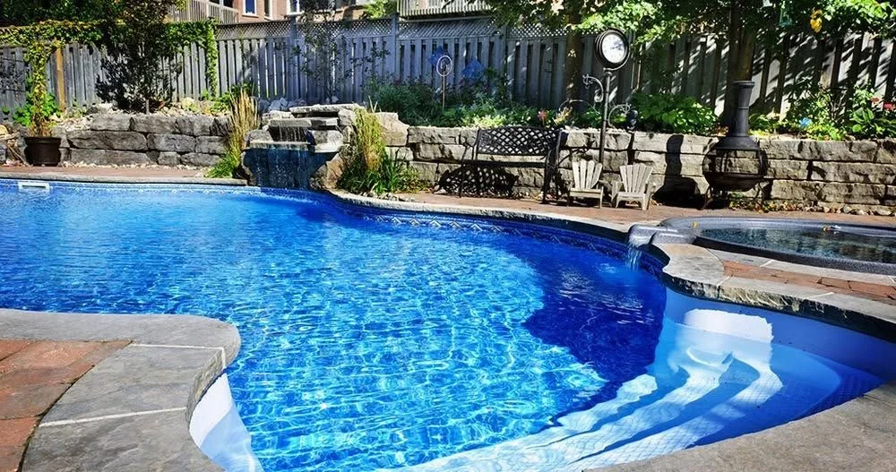 Clear blue pool beside a rock wall
