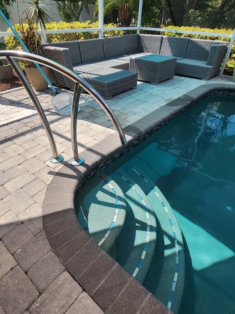 Pool steps with a hand rail and pavers in Clearwater, FL