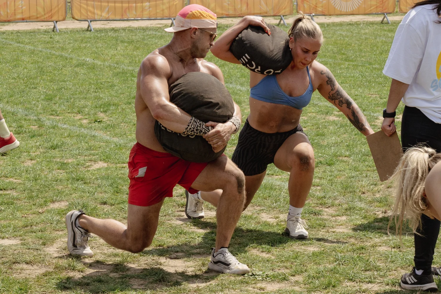 Mixed Throwdown athletes carrying sandbags at Summer Social