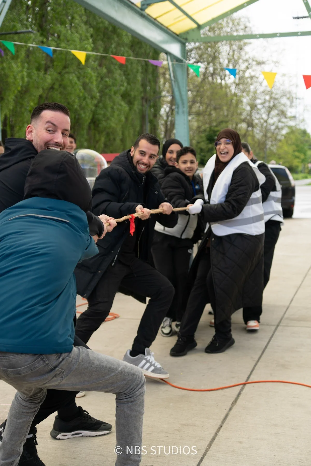 Children and volunteers pulling together in a tug of war