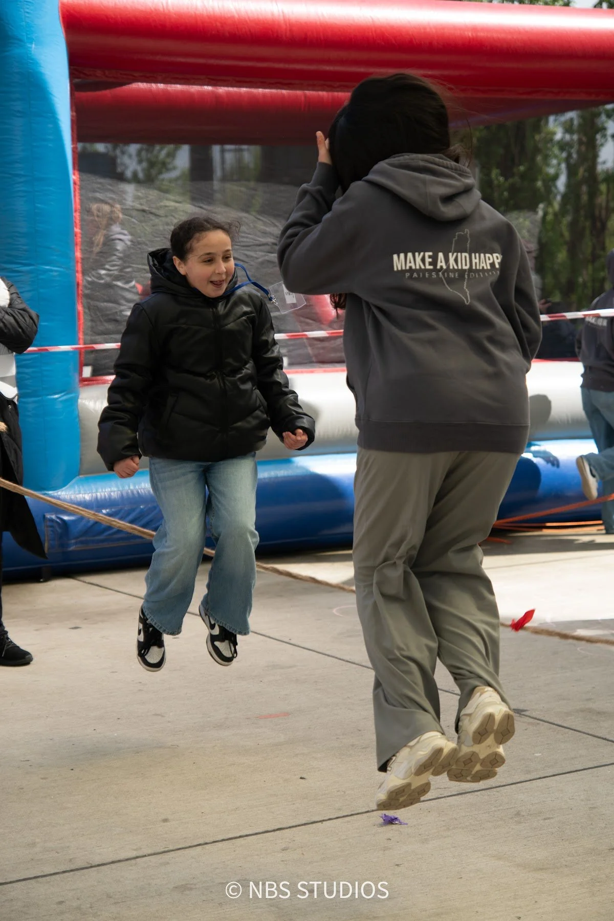 A girl jumping for joy at the Make A Kid Happy Eid Festival