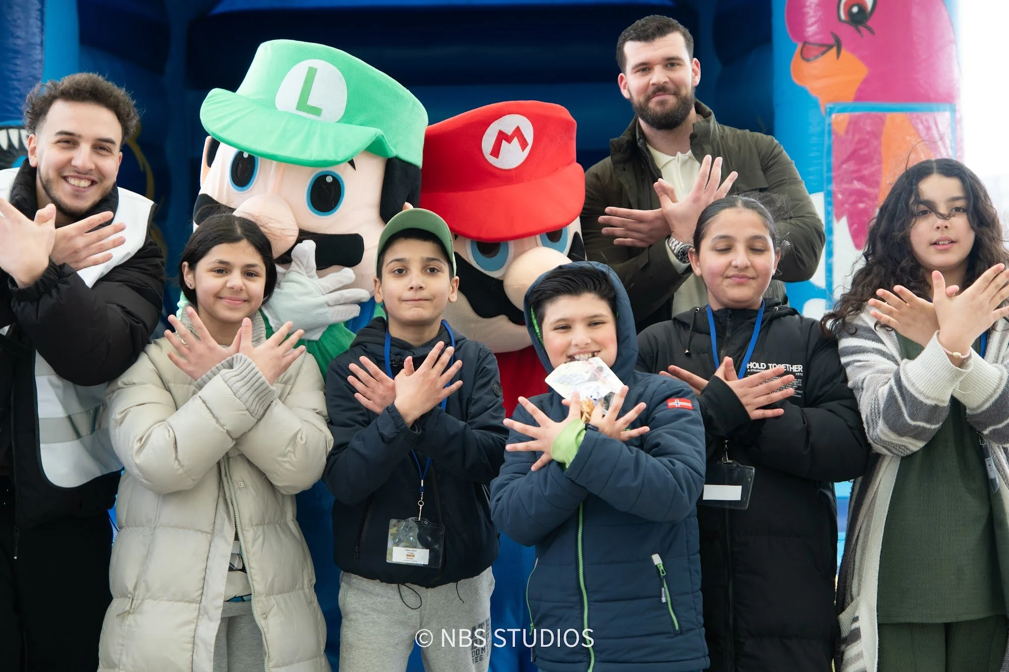 Children and volunteers with Mario and Luigi at the Make A Kid Happy Eid Festival