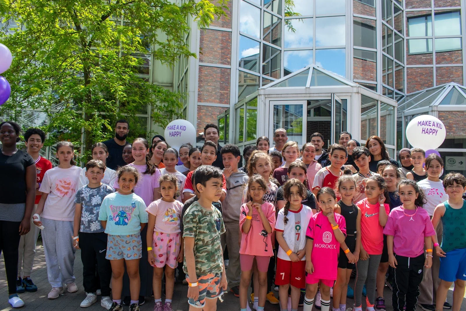 A big group of children and volunteers at a Make A Kid Happy sports day