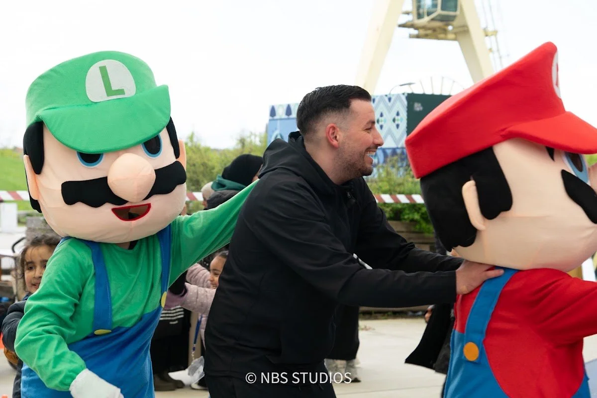 Mario and Luigi greeting a volunteer at the festival