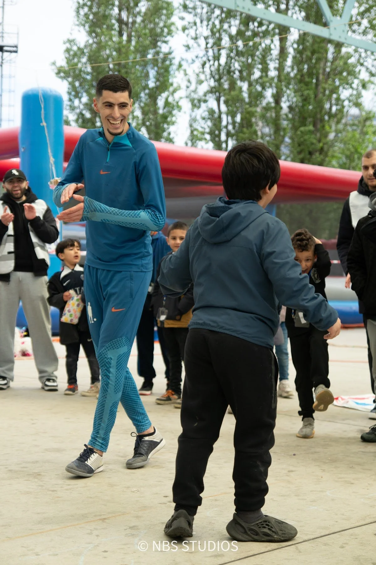 A boy playing football with a freestyle performer