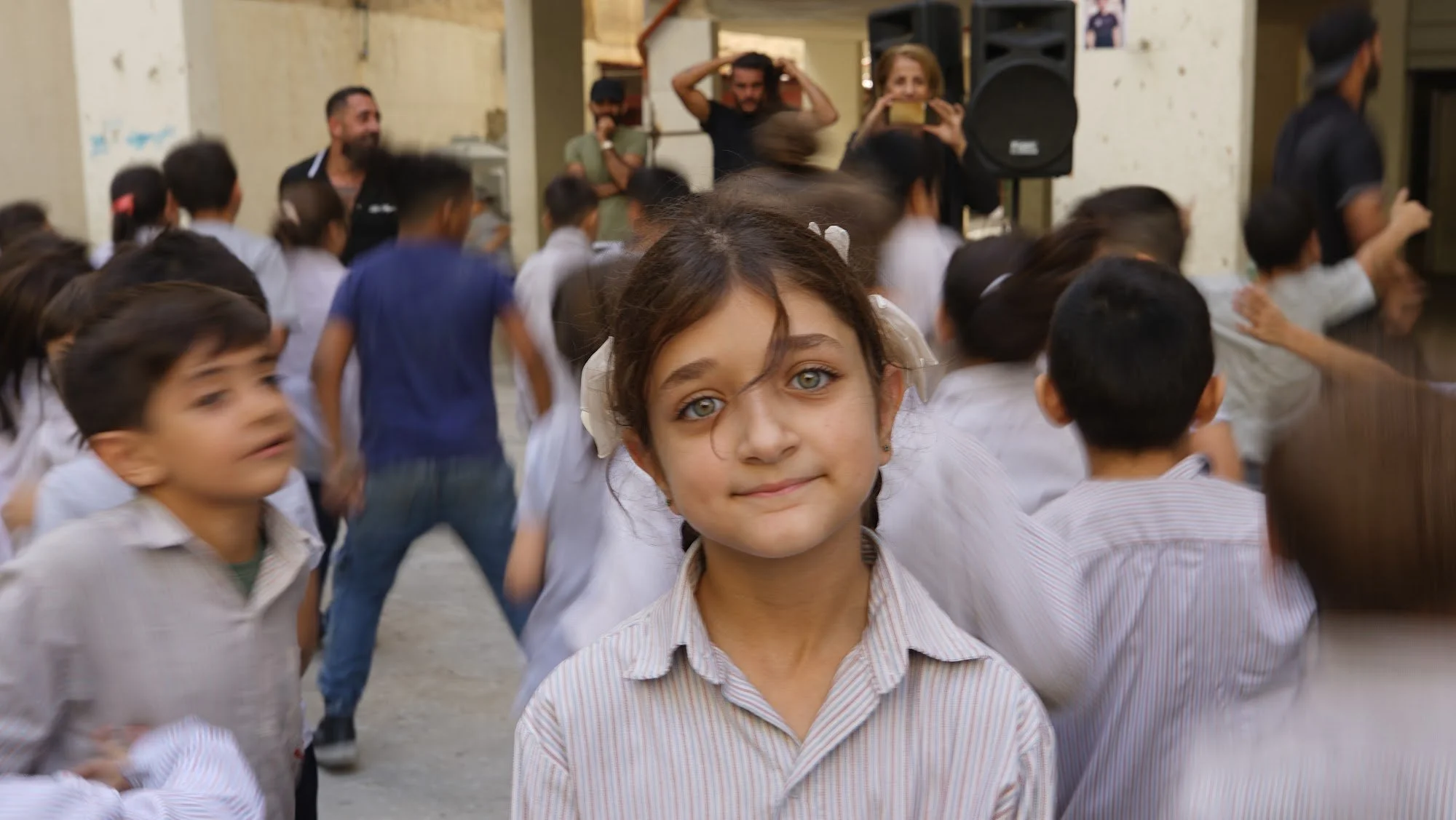 A smiling girl among her classmates during a Make A Kid Happy school visit in Lebanon