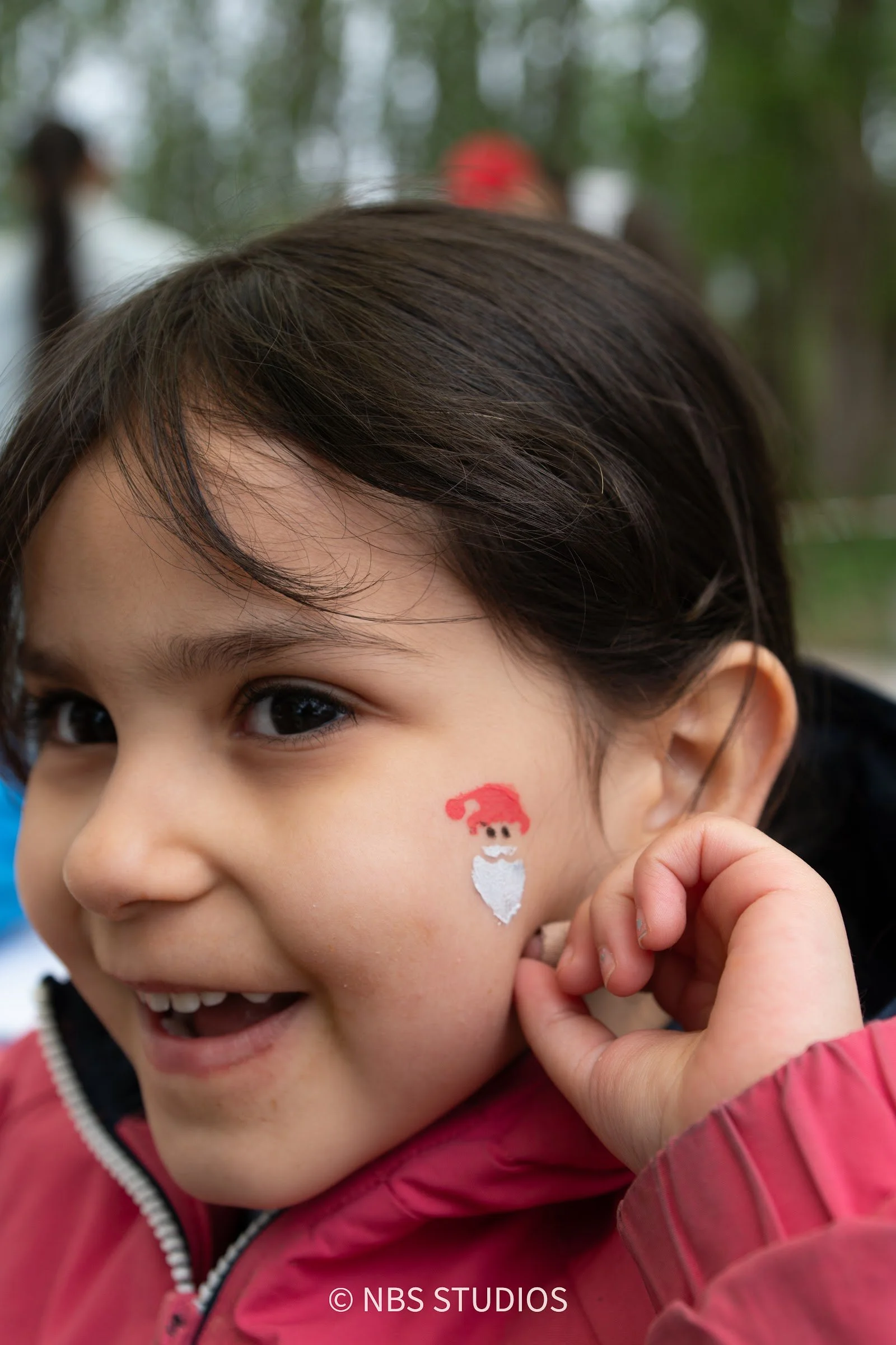 A smiling girl with face paint at a Make A Kid Happy festival