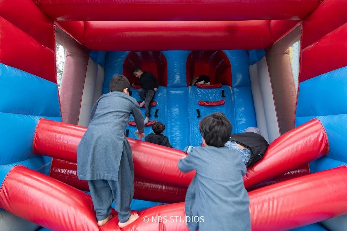 Children climbing into a bouncy castle