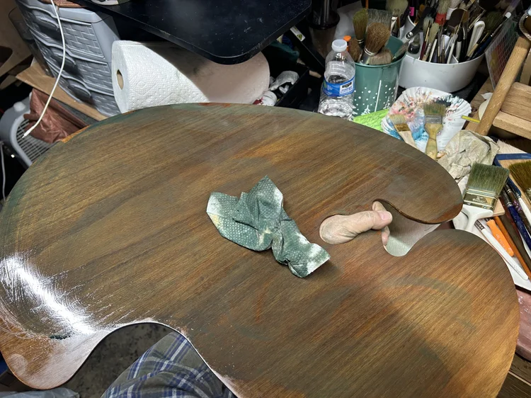 Johnny wiping the finish onto a wooden palette in his studio