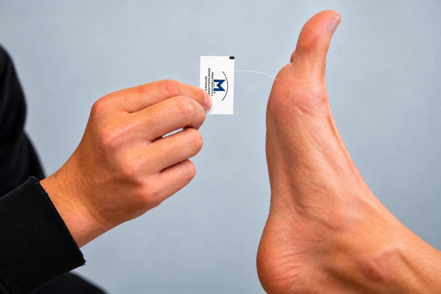 A clinician touching a Medical Monofilament to the sole of a patient's foot