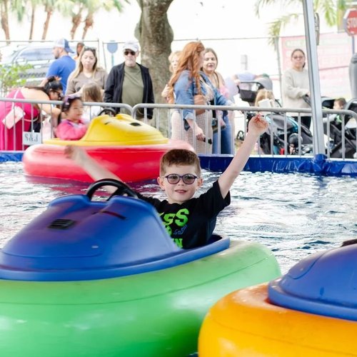 Boy cheering on the bumper boats