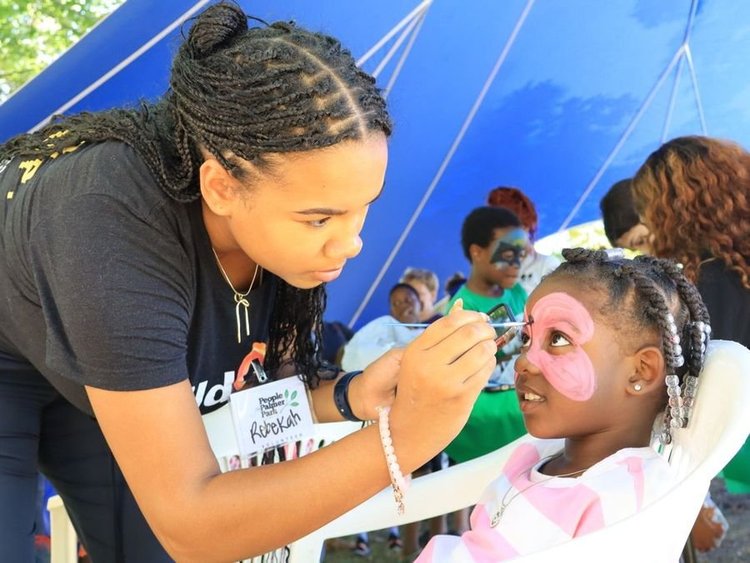Child getting her face painted at a festival
