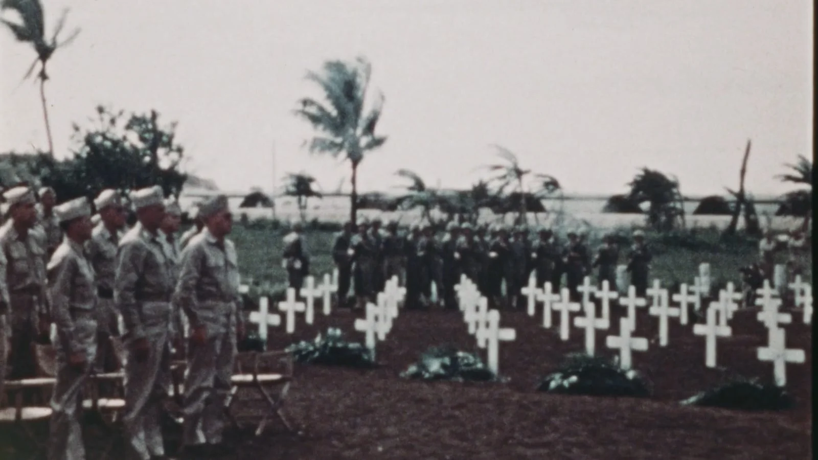 Archival photograph of soldiers at a cemetery of white crosses on Guam