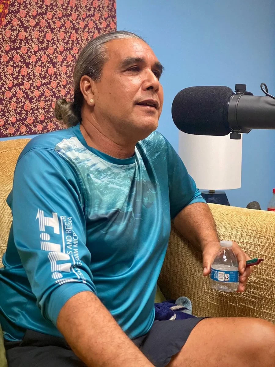 A guest speaks into a studio microphone during a Memoirs Pasifika recording