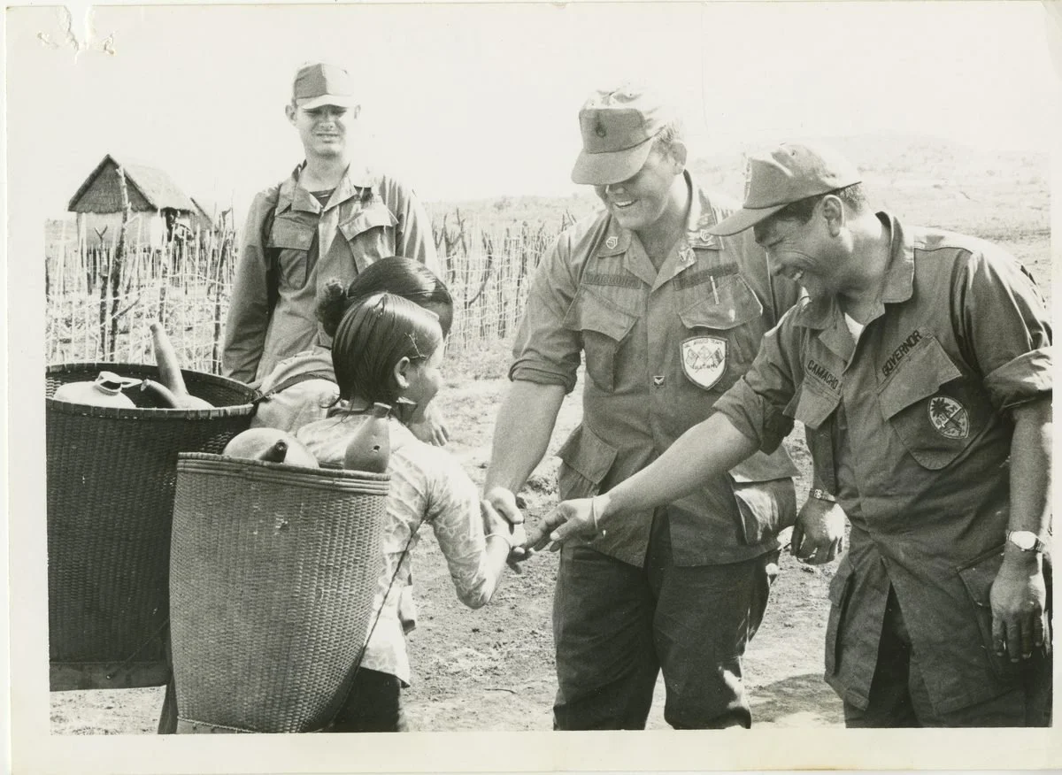 Archival photograph of soldiers with a child in Vietnam