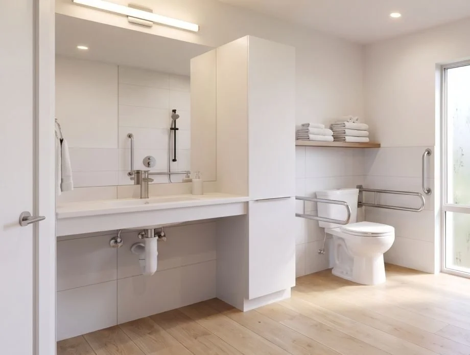 Accessible ADU bathroom with grab bars by the toilet and shower, roll-under sink and step-free floor