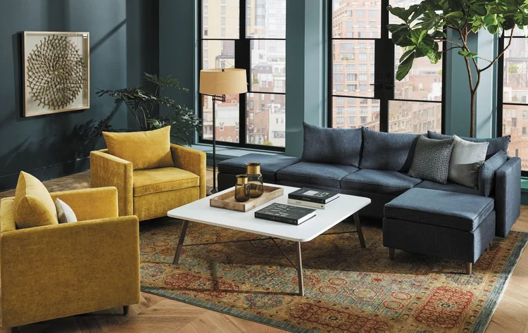 Mustard armchairs and a navy sectional in a city loft