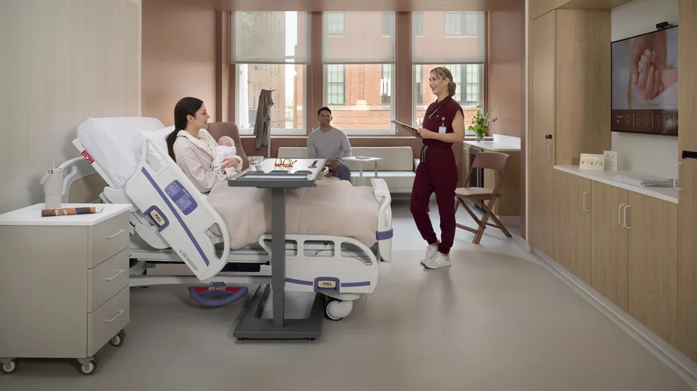 Patient room with a new mother, family member and nurse